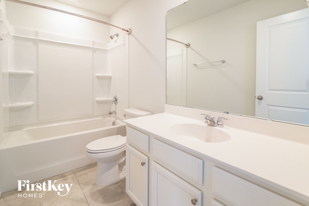 a white bathroom with a sink toilet and shower