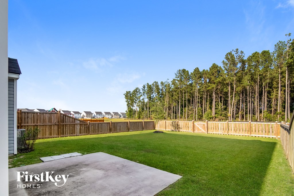a backyard with a fenced in lawn and a privacy fence