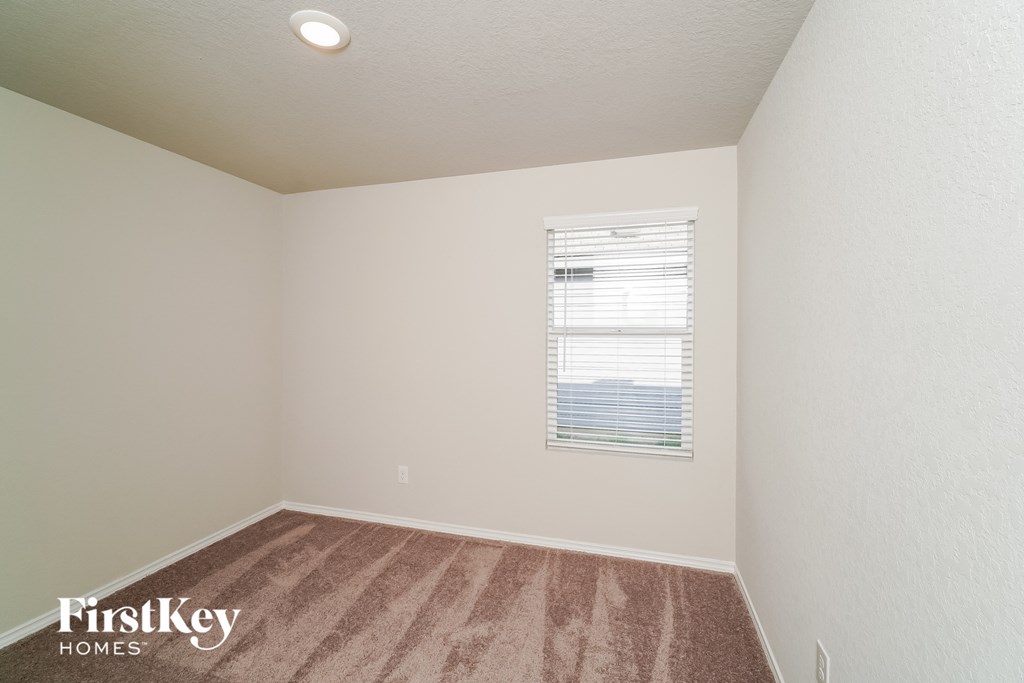 the upstairs bedroom with carpet and a window