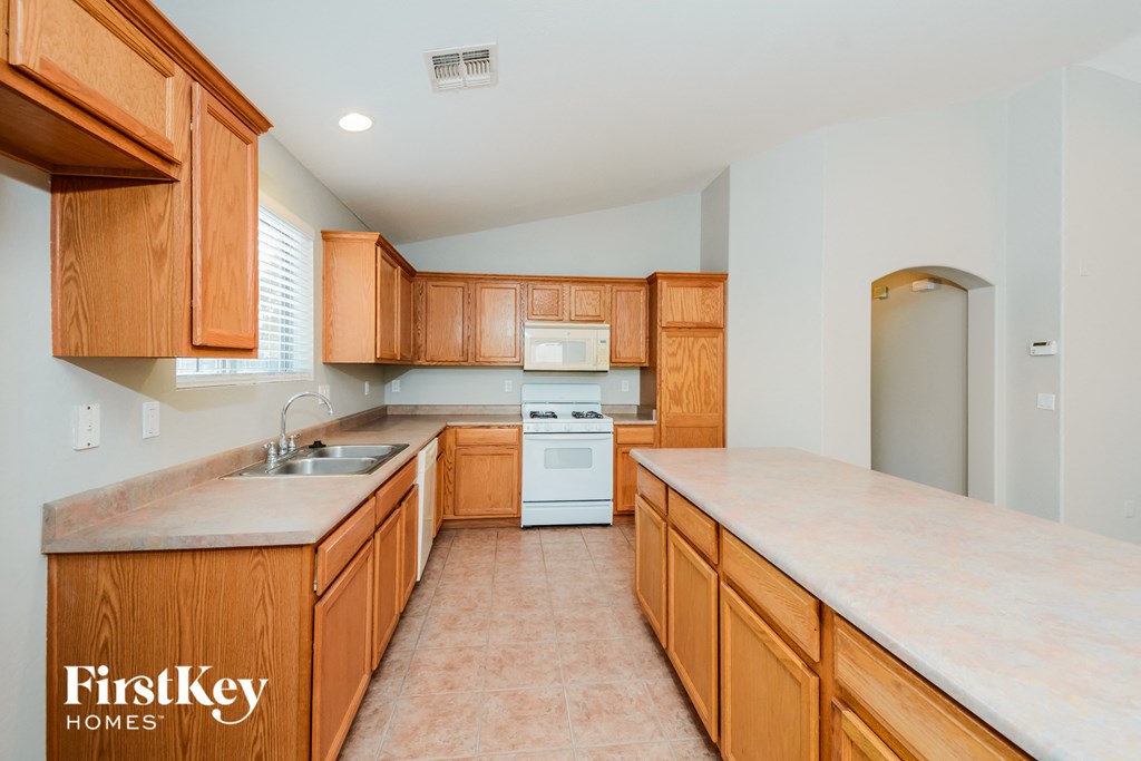 A kitchen with wooden cabinets and a white oven.