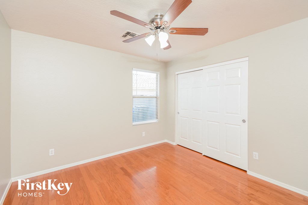 A room with a wooden floor and a ceiling fan.