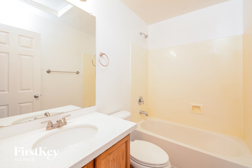 A white bathroom with a toilet, sink, and bathtub.