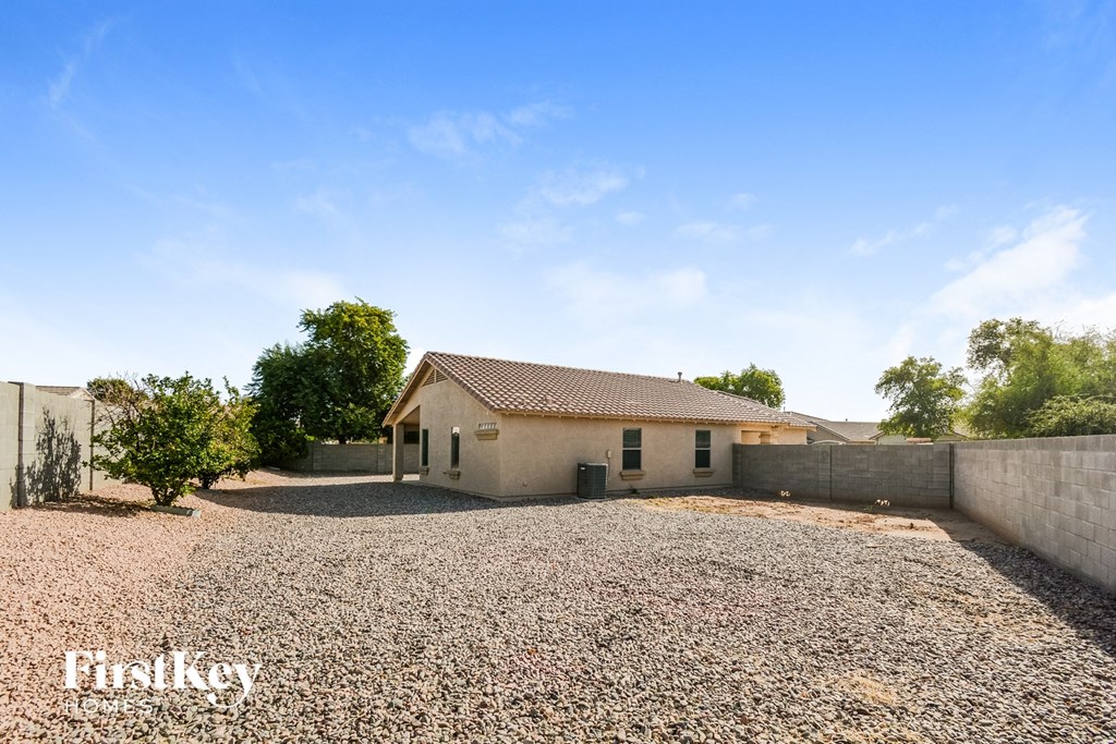 A house with a gravel driveway in front of it.