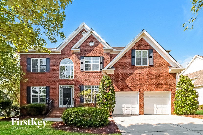 a red brick house with white doors and a garage