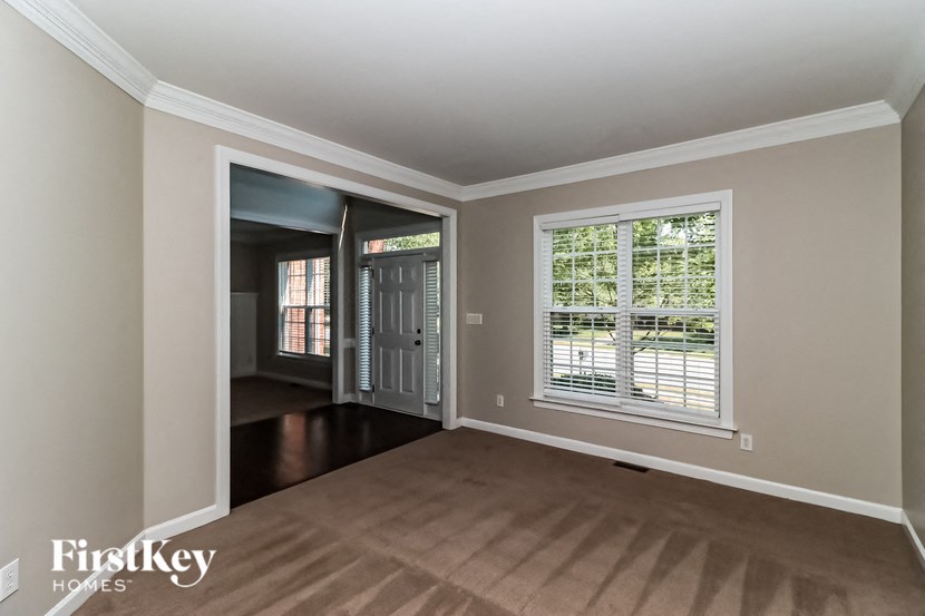 an empty living room with a large window and wood flooring