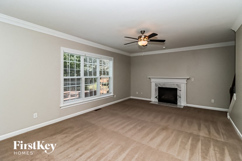a living room with a fireplace and a ceiling fan