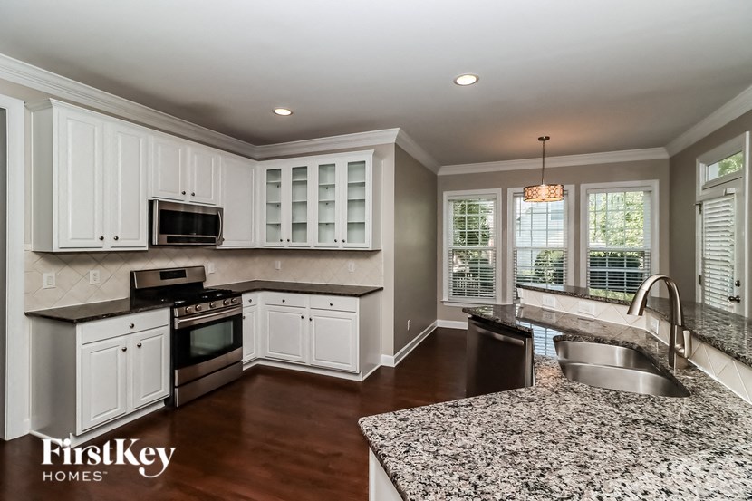 a kitchen with granite counter tops and white cabinets