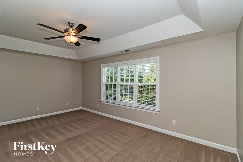an empty room with a ceiling fan and a window