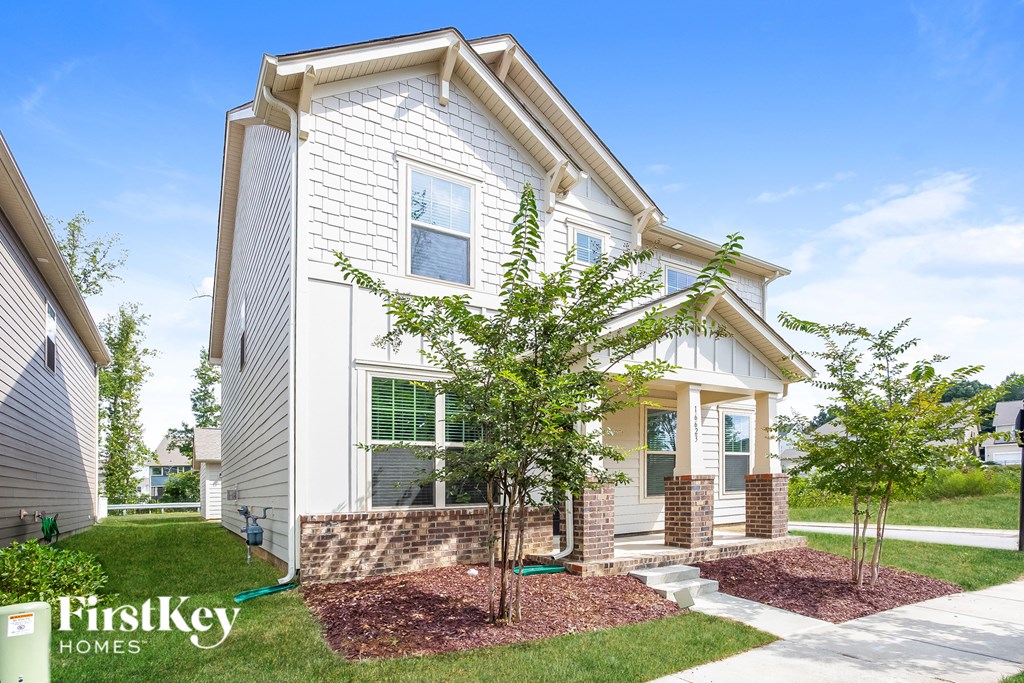 a white house with a tree in front of it