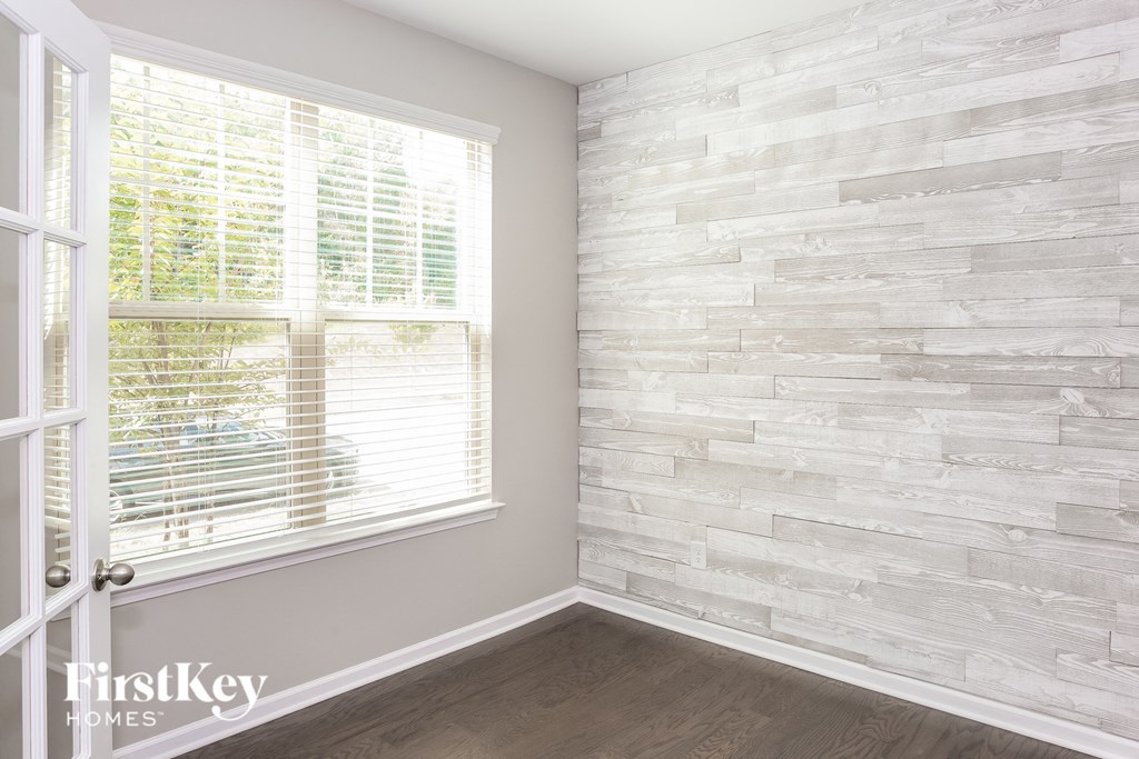 an empty room with a window and a brick wall