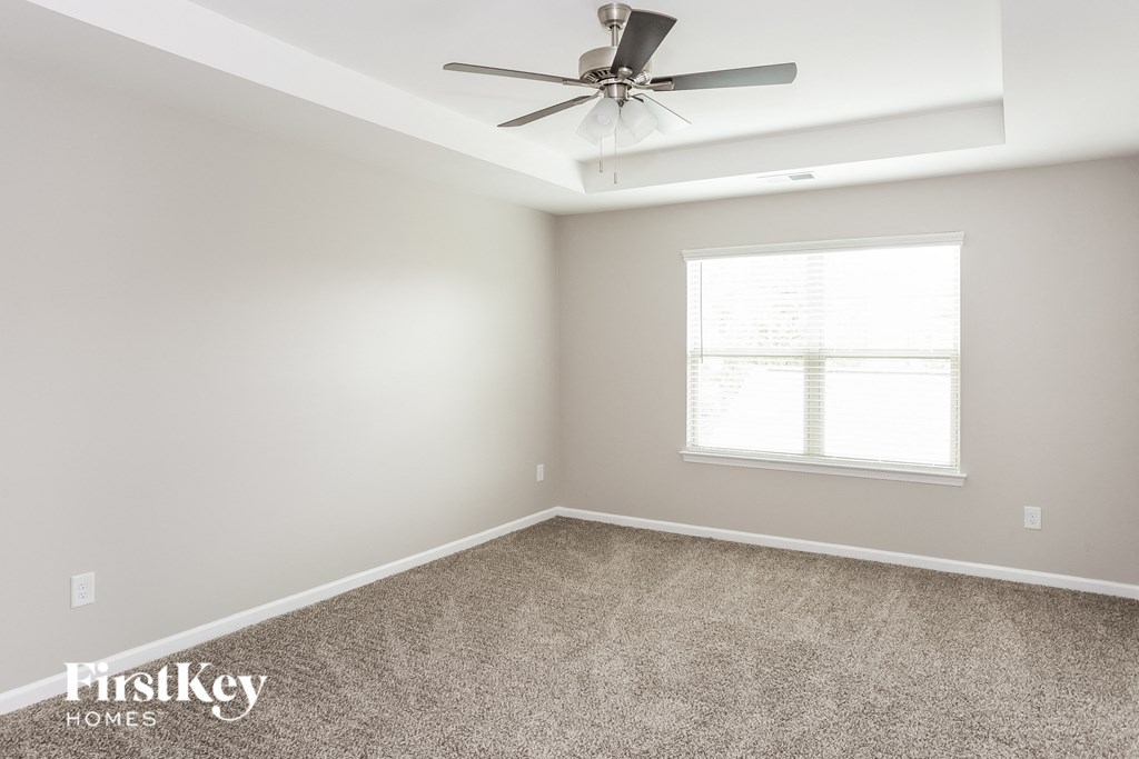 an empty room with a ceiling fan and a window