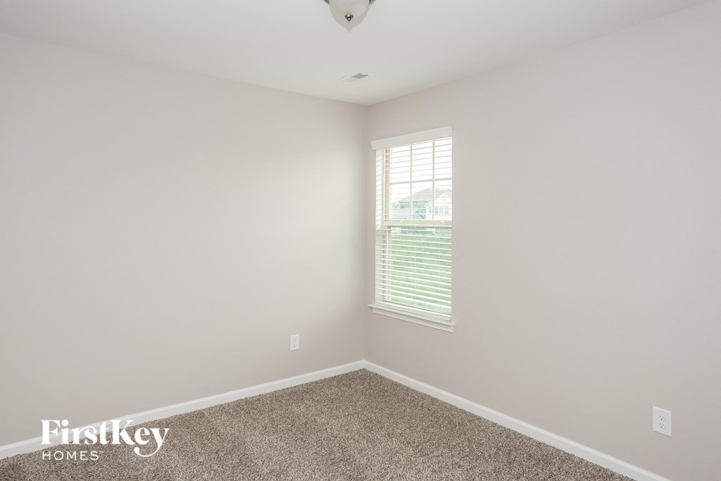 a empty room with carpet and a window
