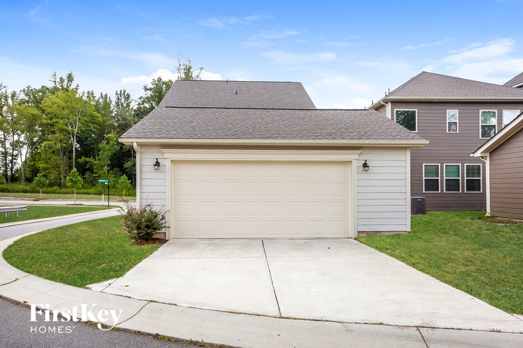 a white garage with a white driveway in front of a house
