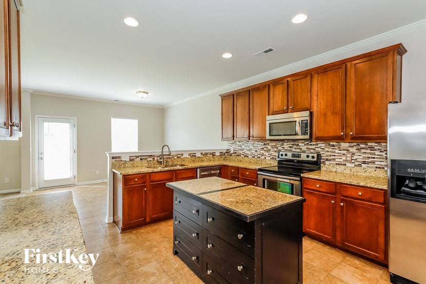 a kitchen with wooden cabinets and granite counter tops and stainless steel appliances