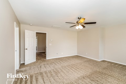 a living room with carpet and a ceiling fan