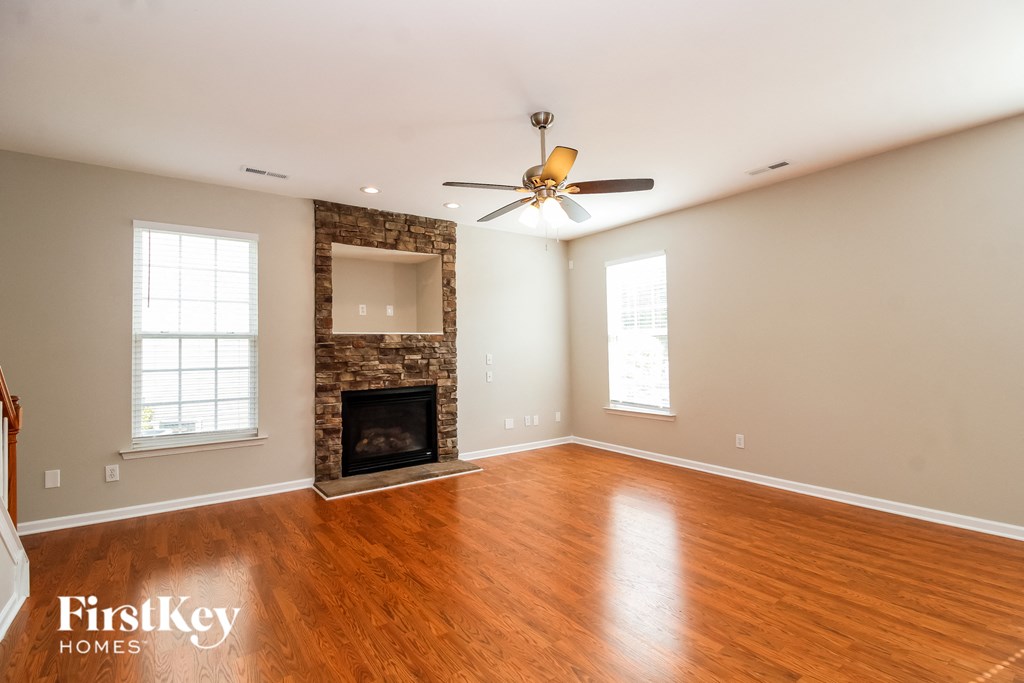 A spacious room with a fireplace and a ceiling fan.