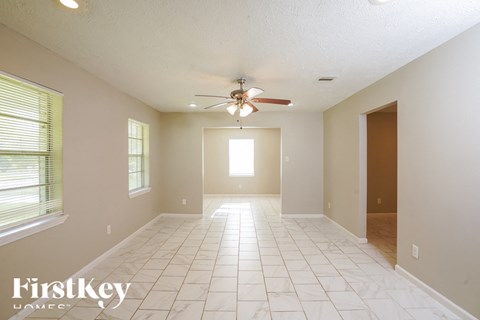 A spacious room with a ceiling fan and tiled floor.