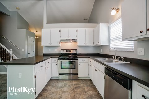 A kitchen with white cabinets and a stainless steel oven.