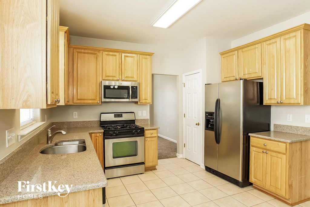 a kitchen with wooden cabinets and stainless steel appliances