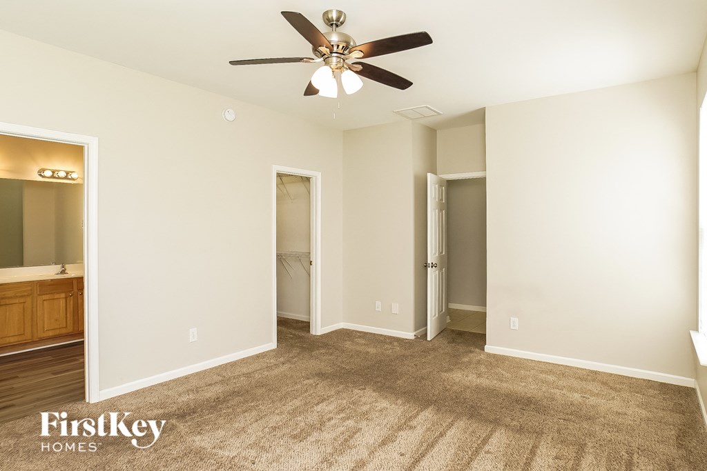 a living room with carpet and a ceiling fan