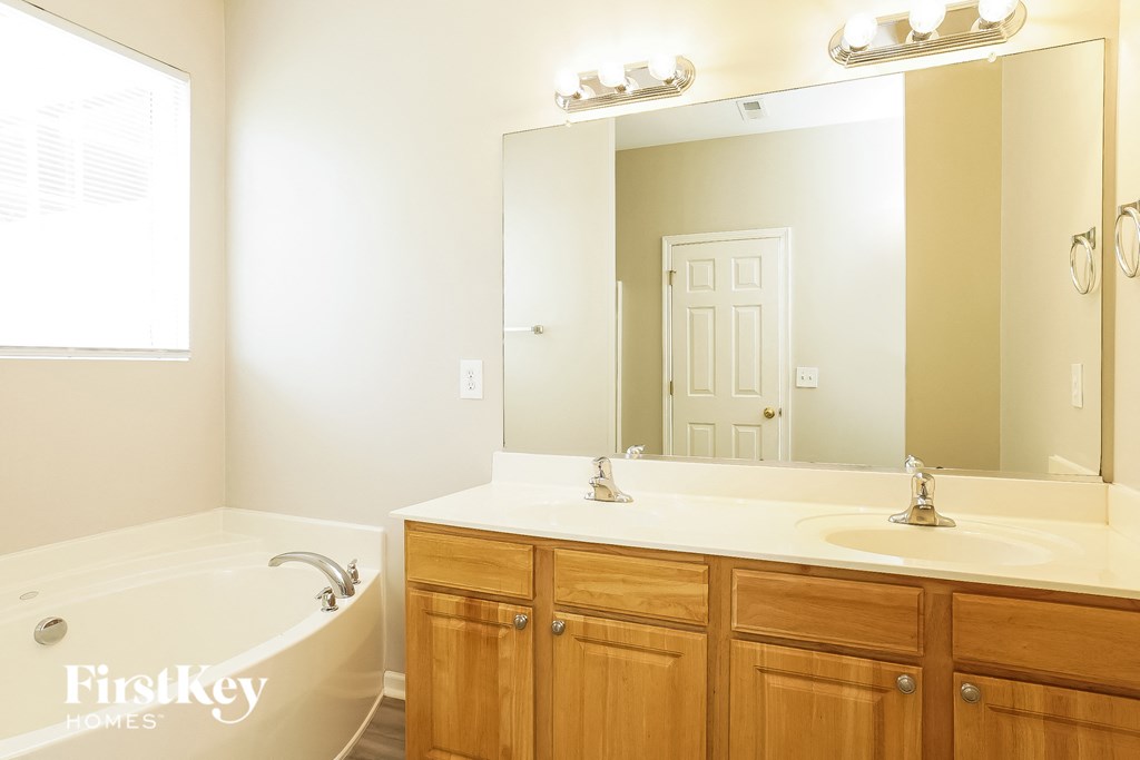 a bathroom with a tub and a sink and a mirror