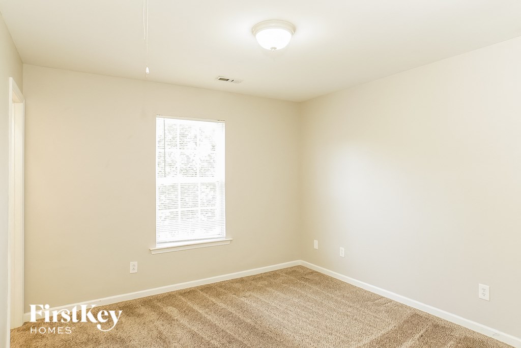 a spacious living room with carpet and a window