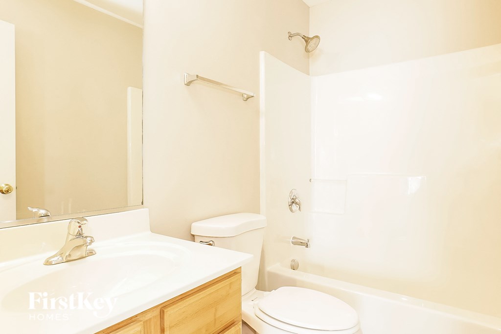 a bathroom with a toilet sink and tub and a mirror