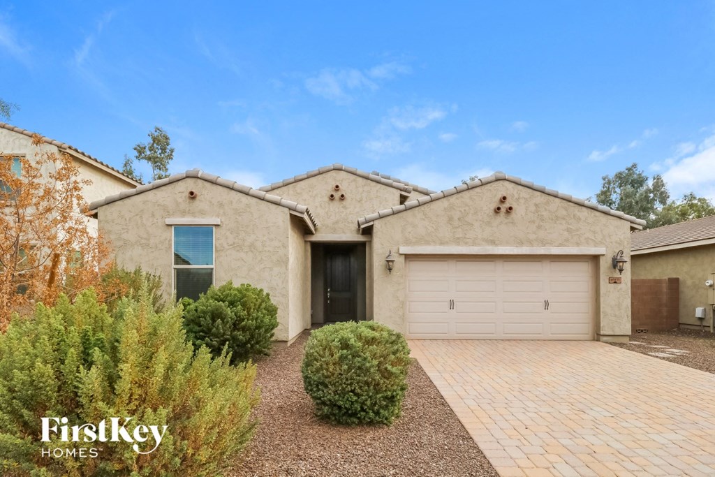 A house with a garage and a driveway in front of it.