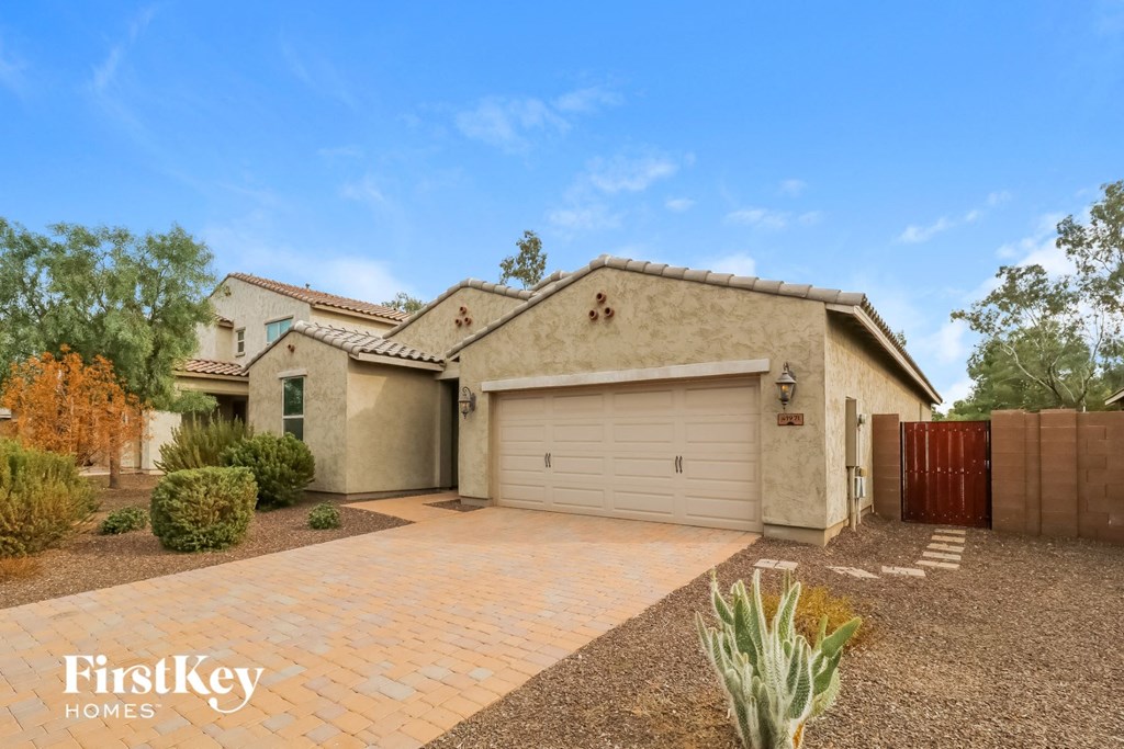 A house with a garage and a driveway in front of it.