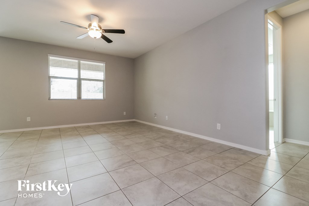 A spacious room with a ceiling fan and a window.