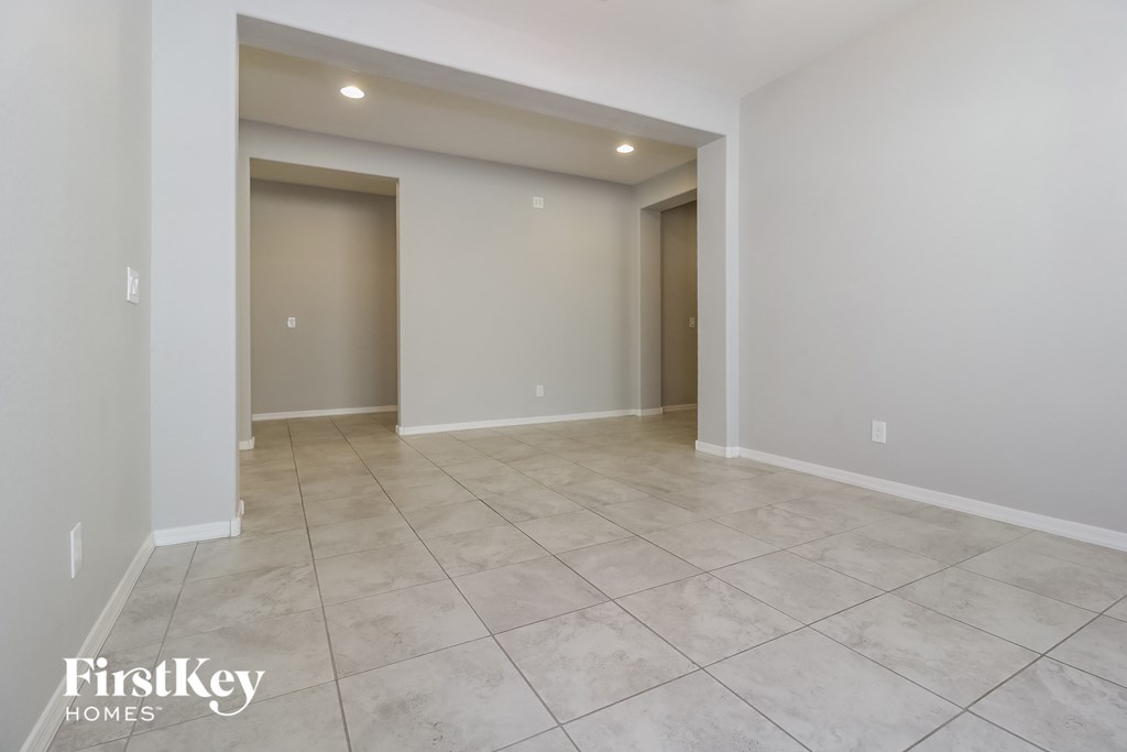 A spacious room with tile flooring and two doors.