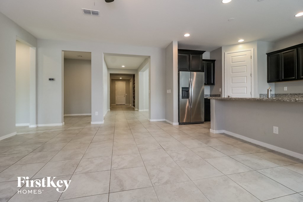 A spacious kitchen with a refrigerator, microwave, and cabinets.