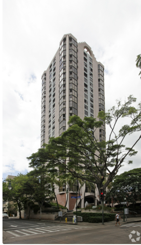 a tall building with a tree in front of it
