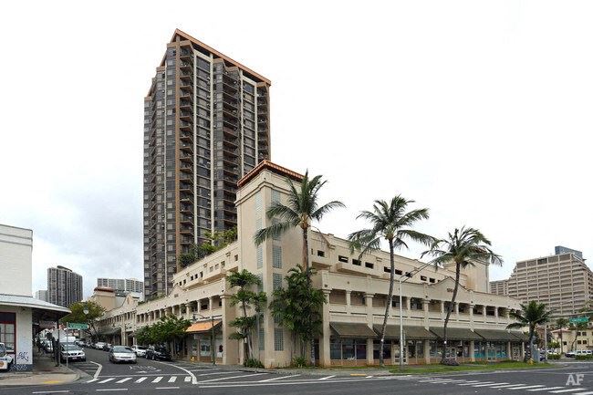 a large building on a city street with palm trees
