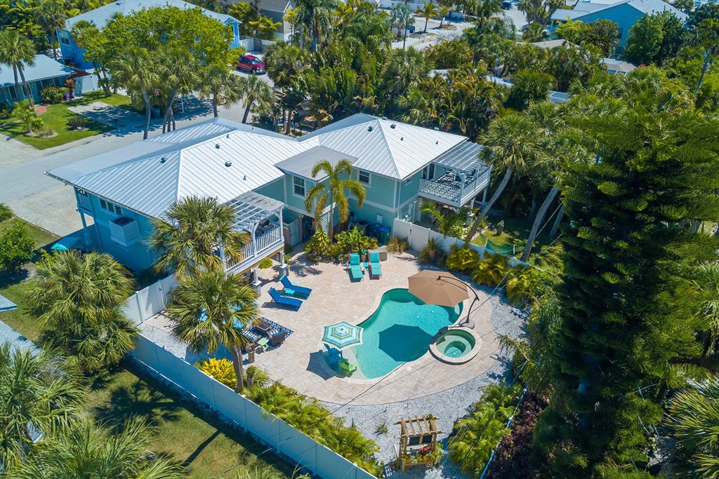 a home with a swimming pool and a backyard with palm trees