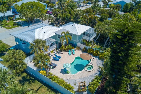 a home with a swimming pool and a backyard with palm trees