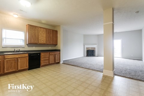 A spacious kitchen with wooden cabinets and a black dishwasher.