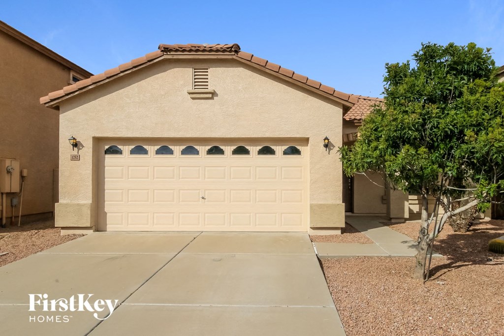 A house with a tan garage door and a brown roof.