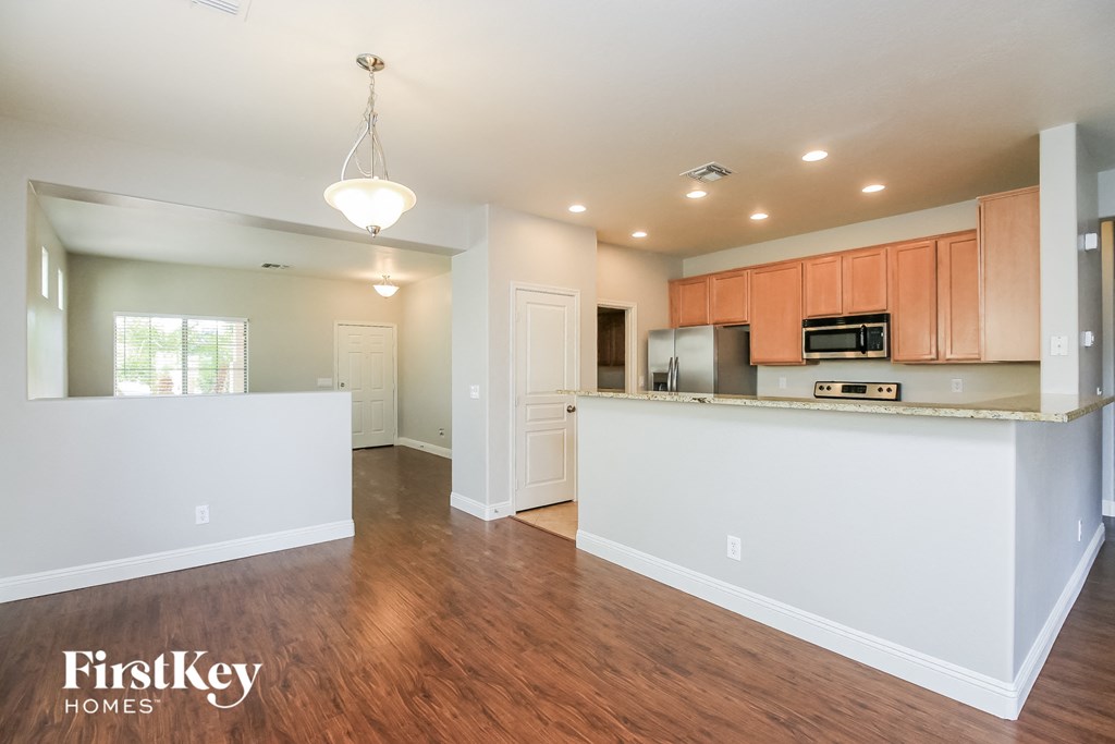A kitchen with wooden floors and white walls.