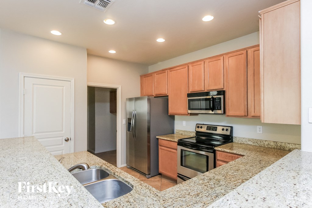 A kitchen with granite countertops and wooden cabinets.