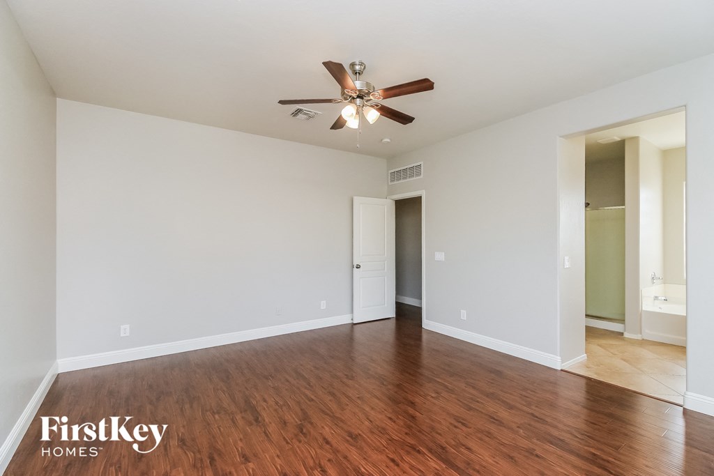 A room with a wooden floor and a ceiling fan.