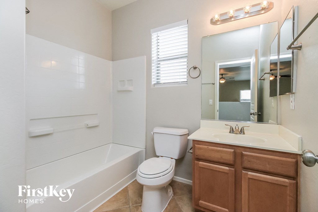 A white bathroom with a toilet, sink and bathtub.