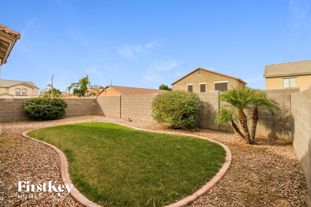 A backyard with a gravel path and a green lawn.