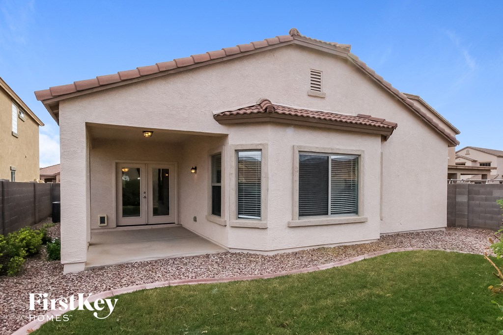 A house with a beige exterior and a red tile roof.