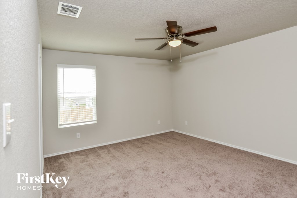 a bedroom with carpet and a ceiling fan