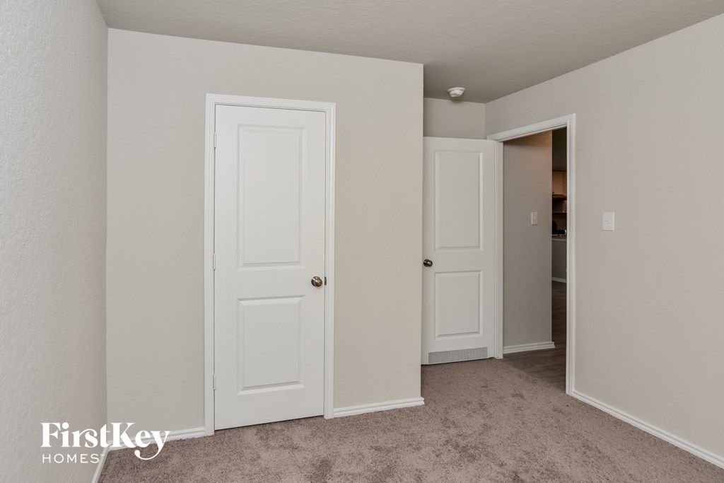 a bedroom with two doors and a door to a closet