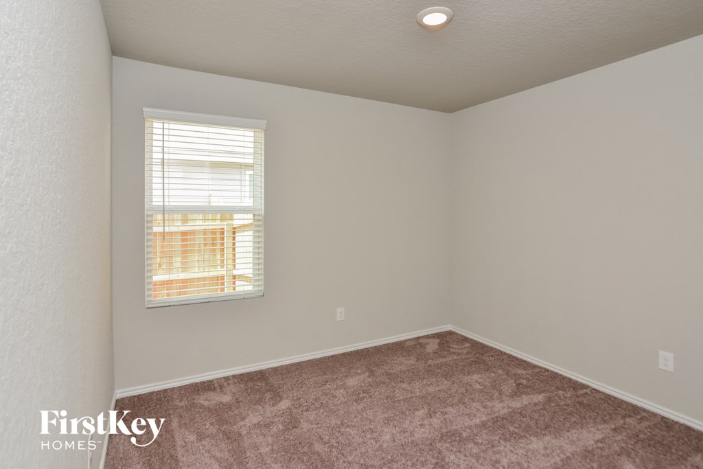 a bedroom with a carpeted floor and a window
