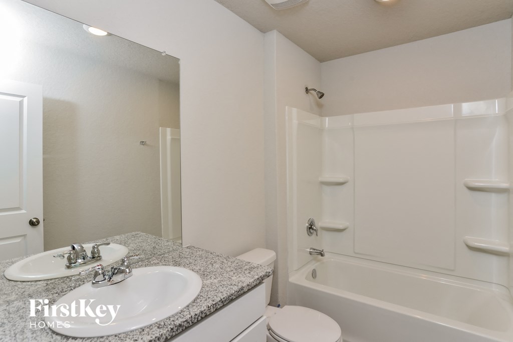 a bathroom with a sink and a shower and a toilet