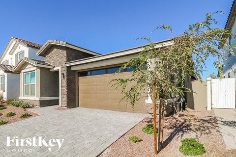 A house with a brown garage door and a tree in front.