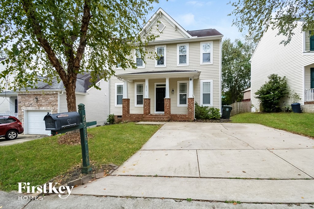 A house with a red car parked in front of it.